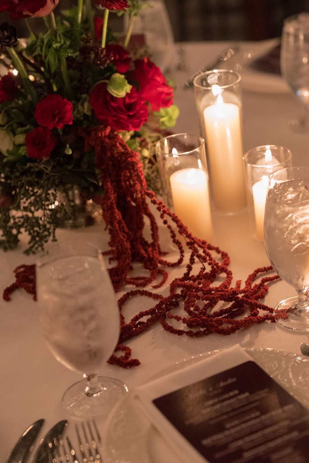 Dark amaranthus with pillar candles in a moody winter wedding tablescape at Saltwater Farm in Stonington, Connecticut.
